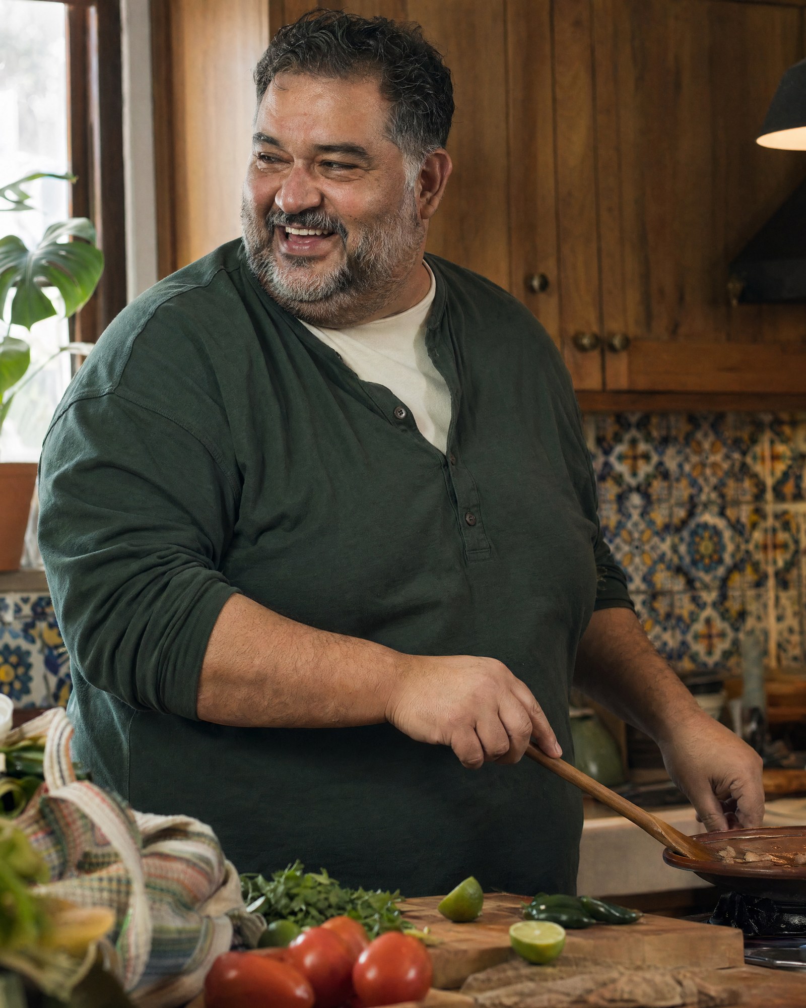Un hombre cocina en su cocina luminosa por la tarde